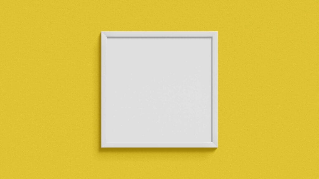 A neatly hung picture frame on a vibrant yellow wall, showcasing handyman side hustles like professional picture hanging services.