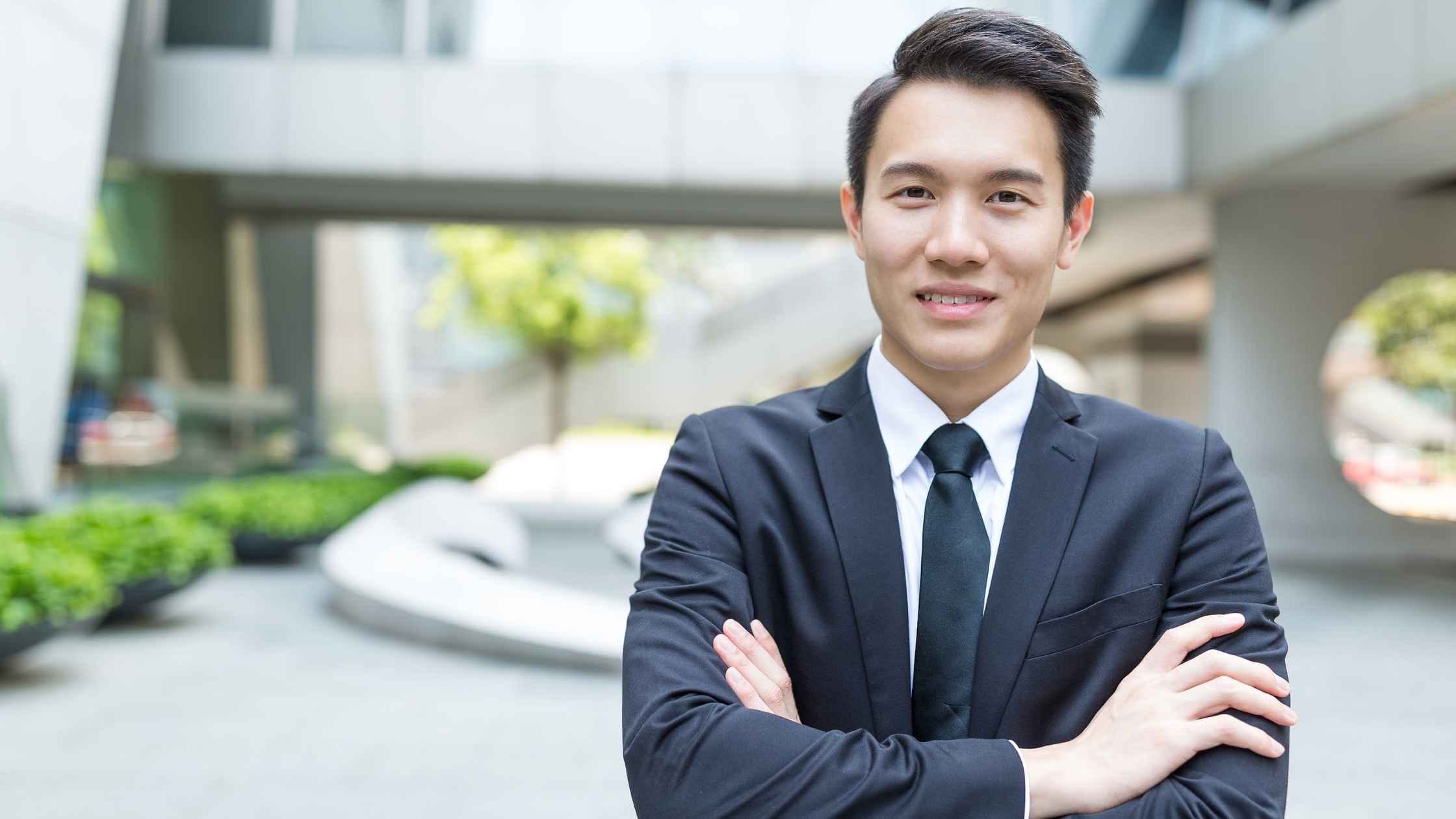 A confident businessman in a suit standing outdoors, representing financial success through side hustles for men.