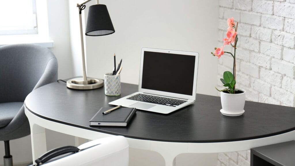Blogging workspace with laptop, notebook, and pens.