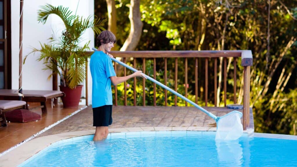 Young man cleaning a swimming pool as one of many spring side hustle ideas