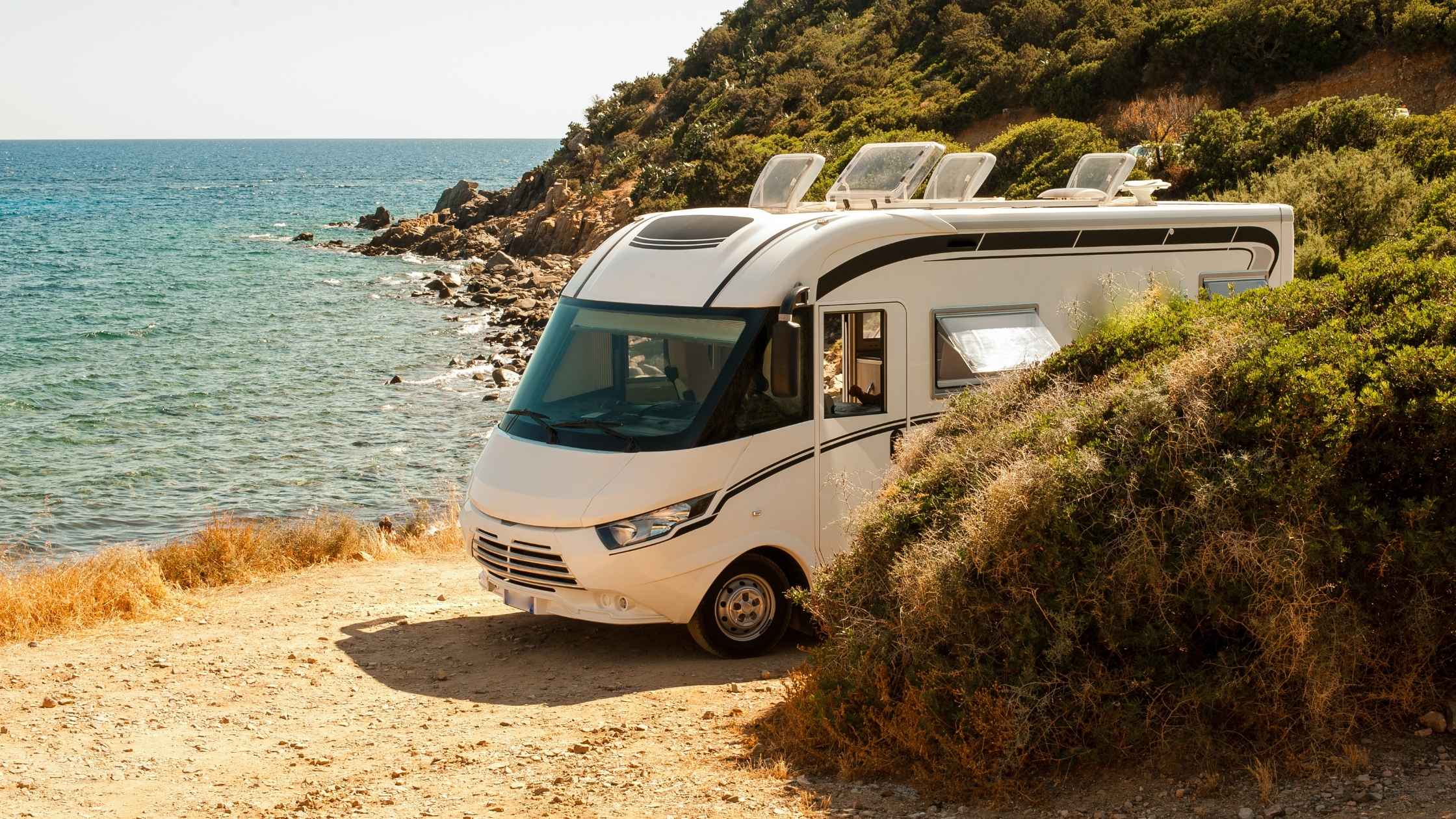 Modern RV parked by the ocean representing the freedom of RV business