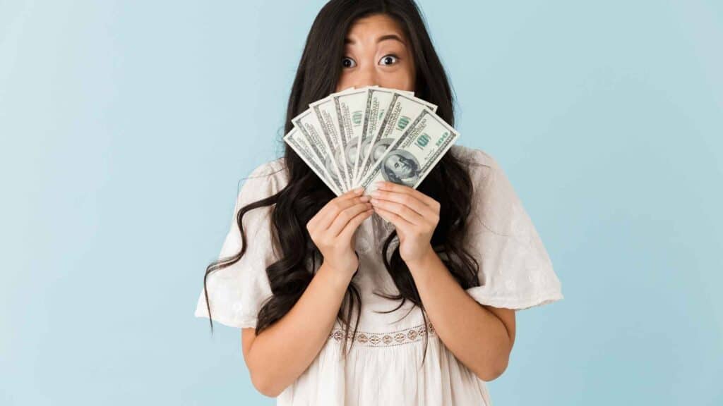 Student holding cash excitedly — representing smart money management for students