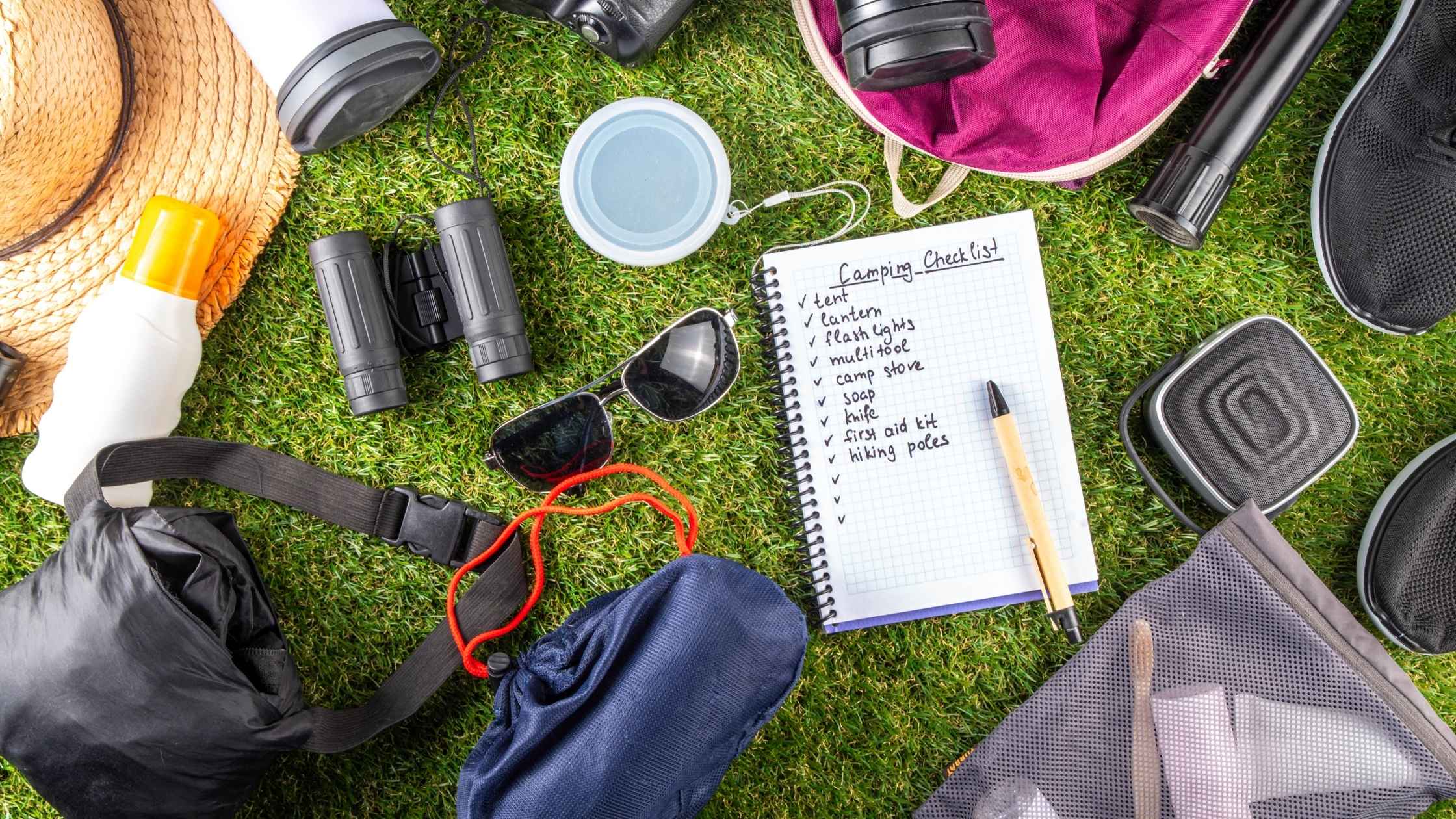 Essential gear checklist laid out on grass for a summer bucket list 2025 adventure
