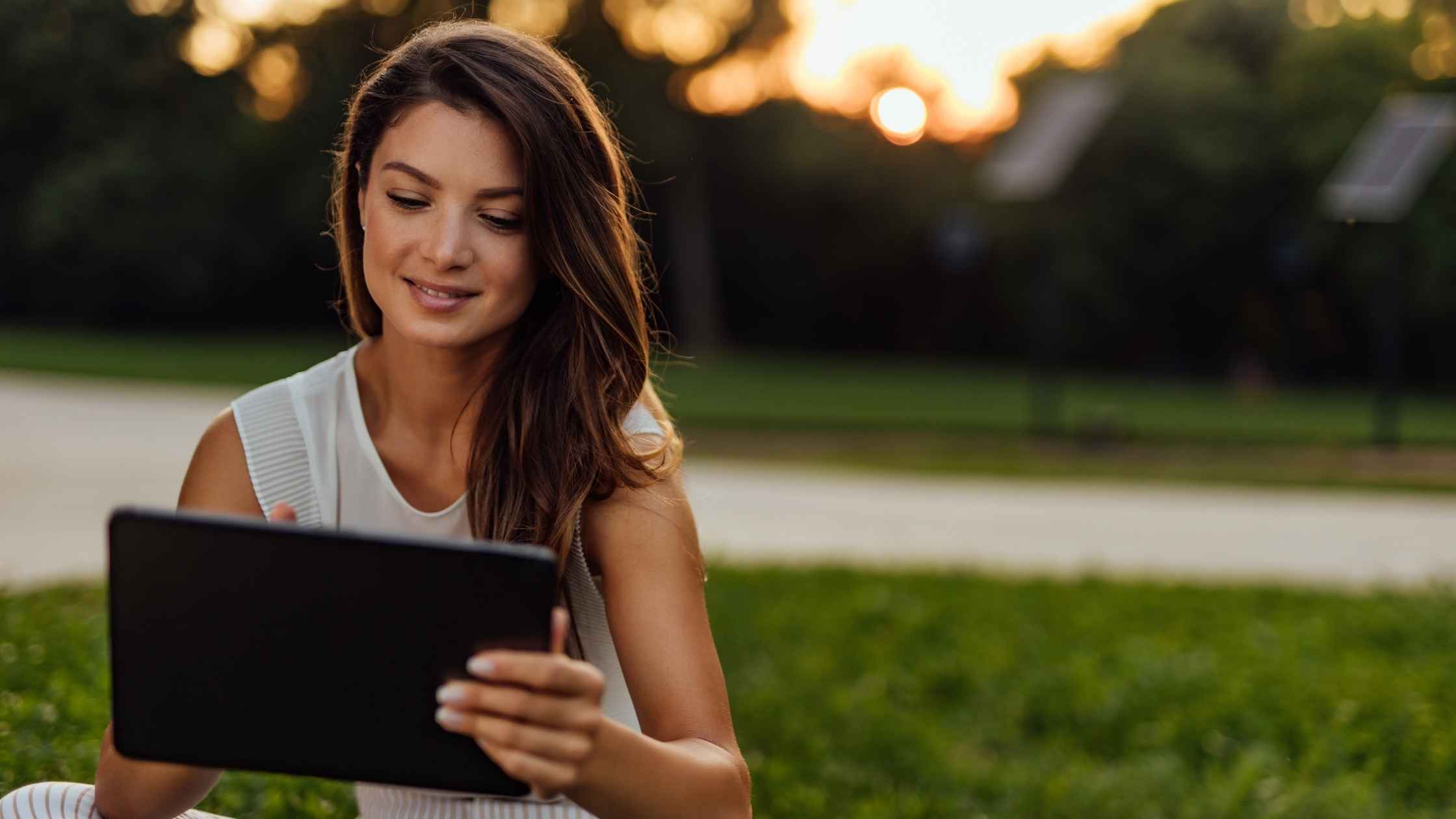 Woman working on a tablet outdoors exploring side job ideas