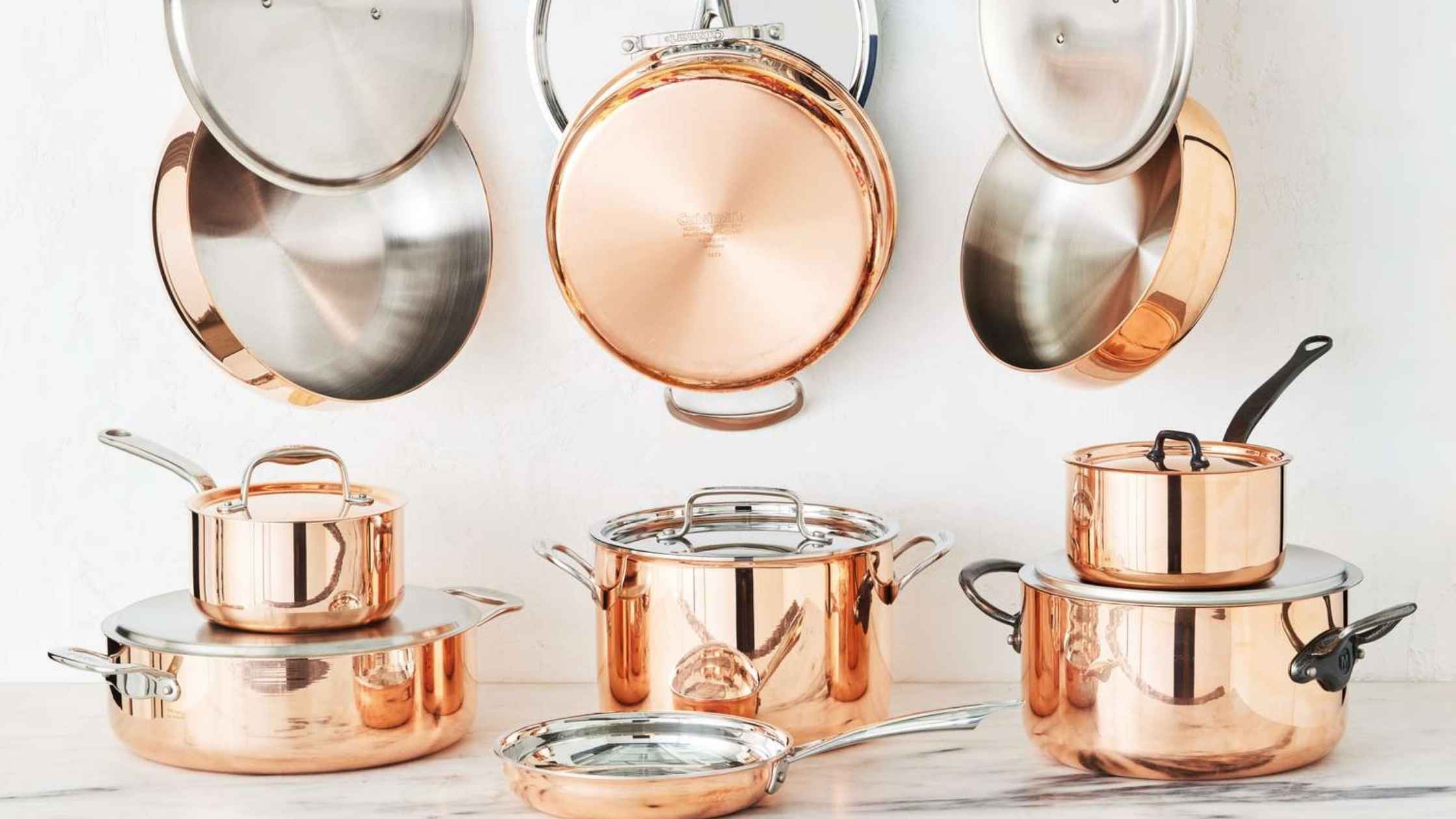 Copper and stainless steel pots and pans arranged as part of diy small kitchen ideas