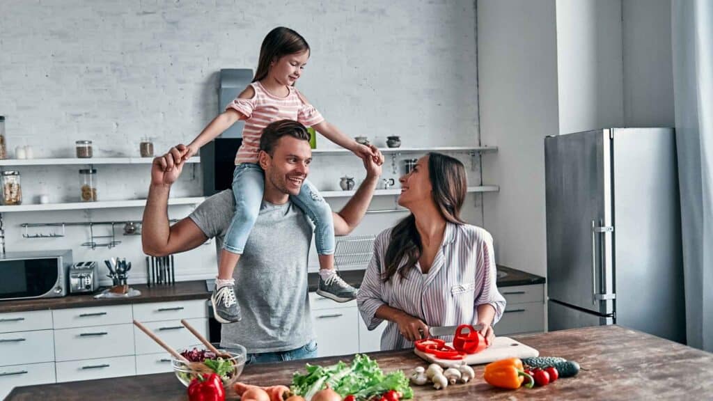 A family cooking dinner together to save money and having fun.