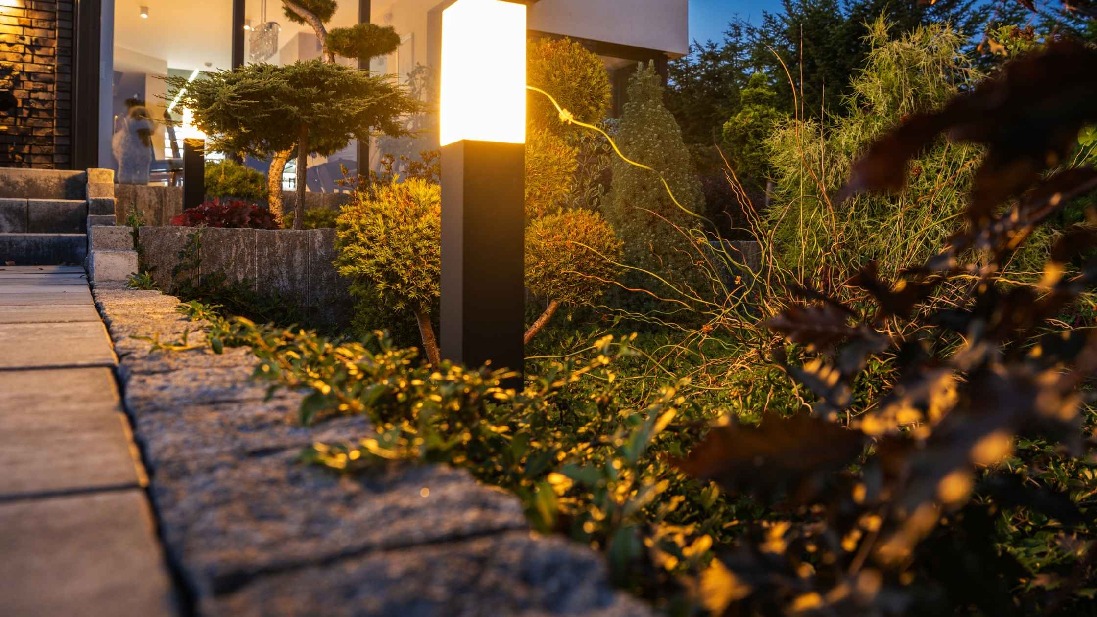 Modern outdoor decor lighting along a landscaped garden path at dusk.