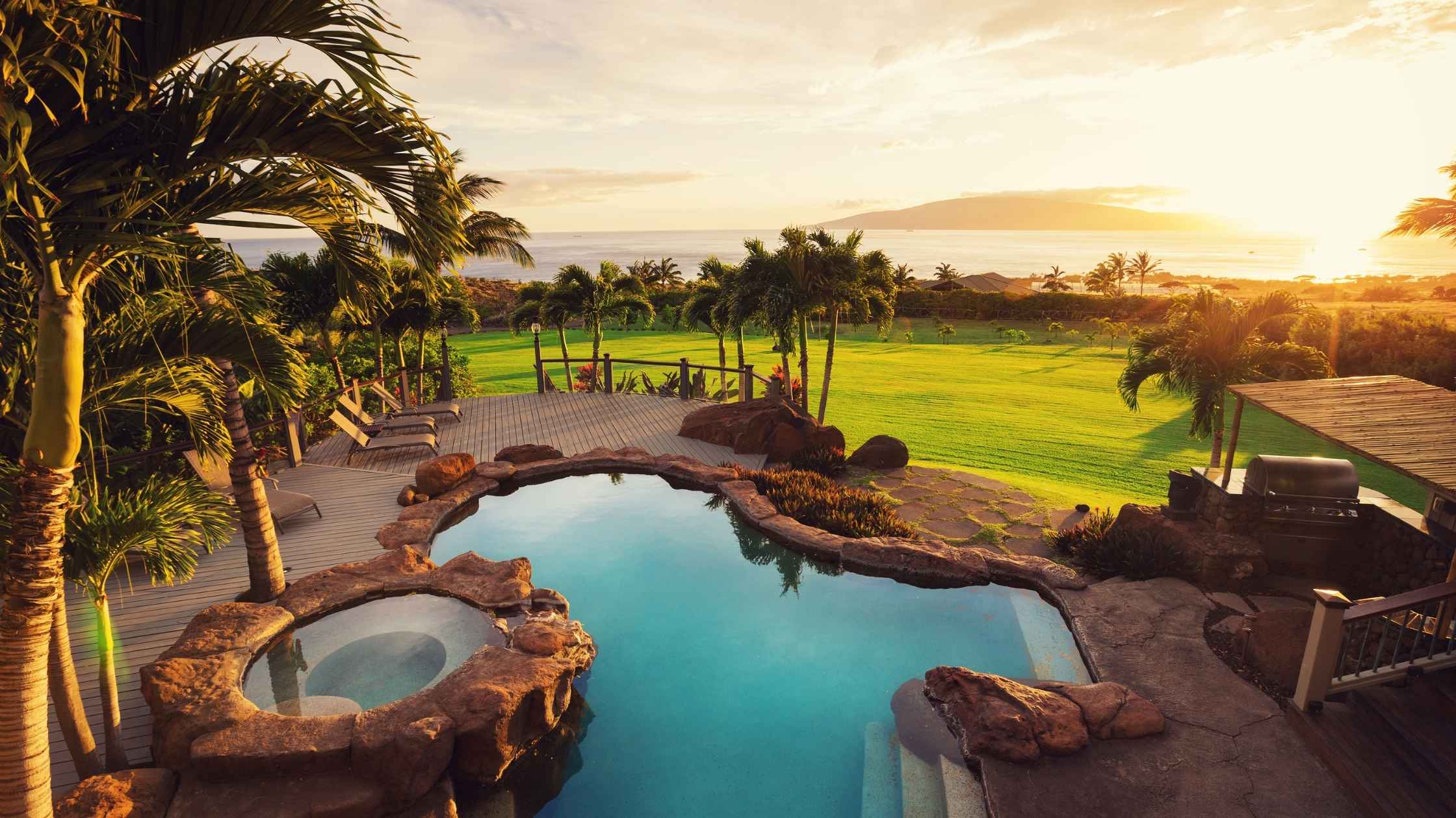 Luxury backyard with pool and ocean view representing a millionaire lifestyle